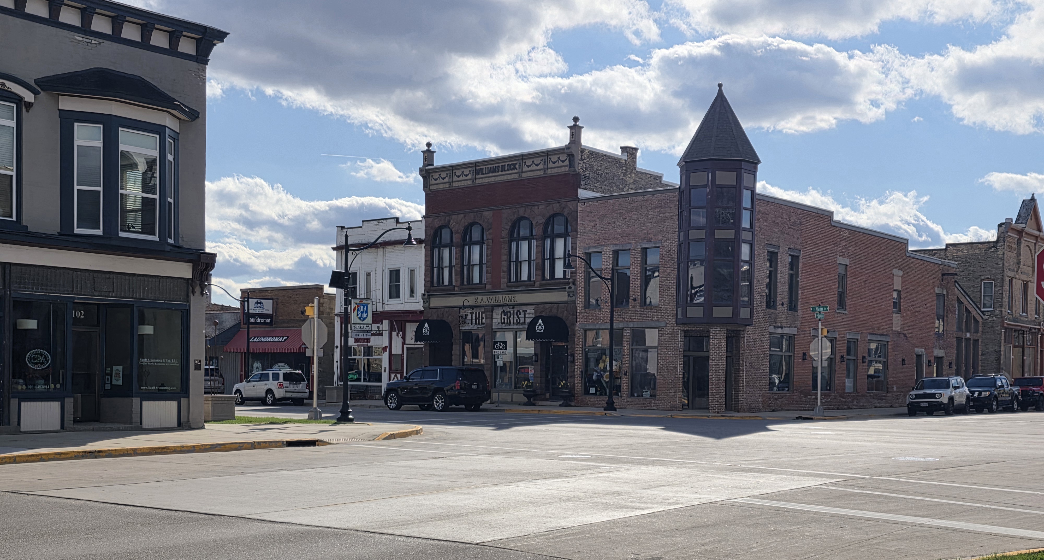 Historic downtown Lake Mills, WI with Victorian-era brick buildings and turret corner building